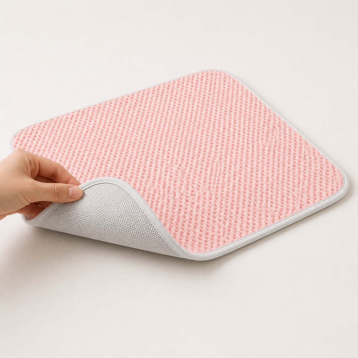 Pink breathable pet mat lifted to show its non-slip underside