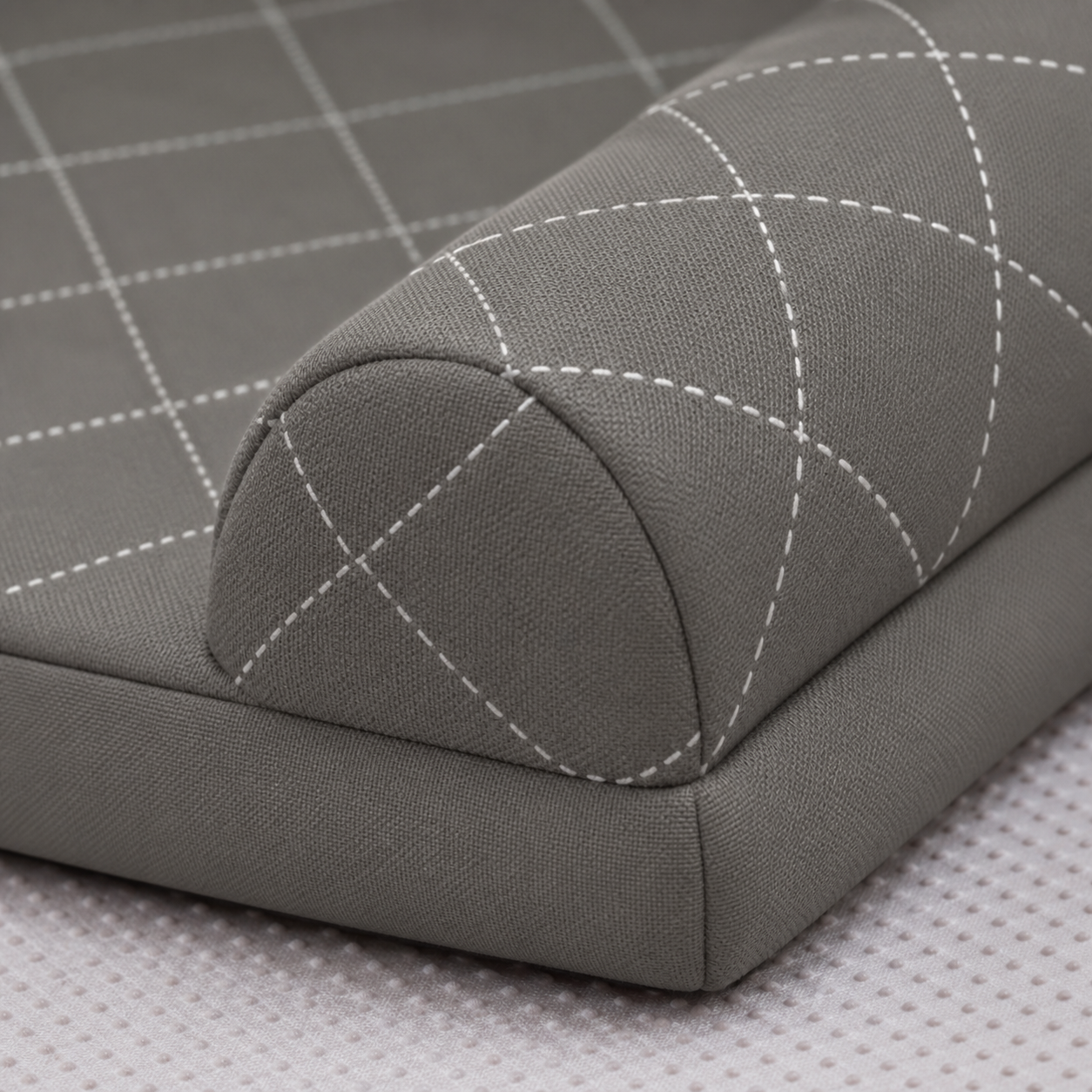 Grey diamond-quilted fabric and raised bolster detail